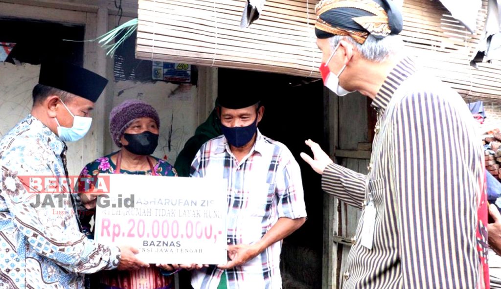 Sumindar, warga Desa Bandungrejo, Kecamatan Mranggen, Demak saat menerima bantuan renovasi RTLH yang secara simbolis diserahkan oleh Ganjar Pranowo. (Dok. Kominfo Demak)