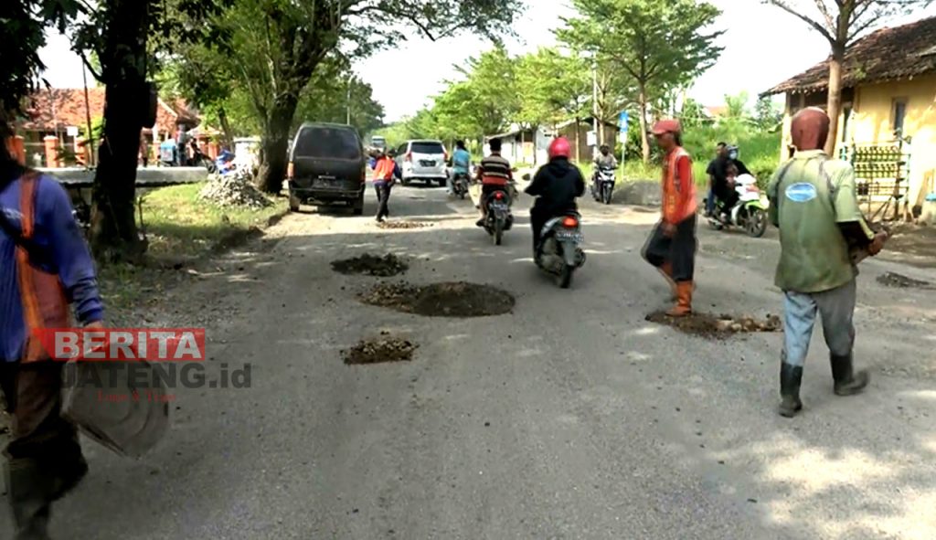 Petugas sedang menabur batu-batuan dan pasir di jalan yang mengalami kerusakan, Kabupaten Brebes. (Tangkapan Layar Lingkar TV)