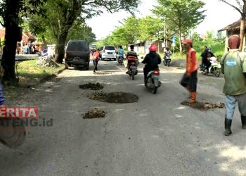 Petugas sedang menabur batu-batuan dan pasir di jalan yang mengalami kerusakan, Kabupaten Brebes. (Tangkapan Layar Lingkar TV)