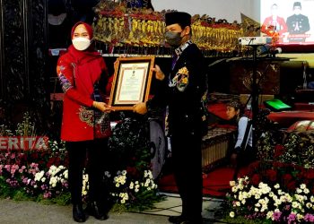 Bupati Eisti'anah menyerahkan penghargaan Satyalancana Karya Satya pada Sekda Demak Singgih Setyono. (Dok. Dinkominfo Demak)