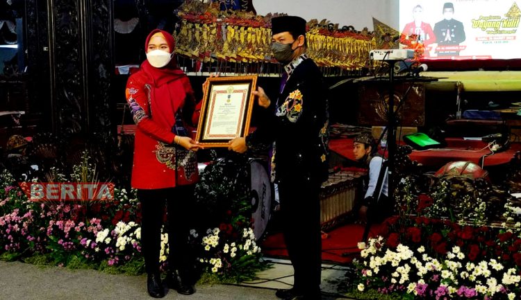 Bupati Eisti'anah menyerahkan penghargaan Satyalancana Karya Satya pada Sekda Demak Singgih Setyono. (Dok. Dinkominfo Demak)