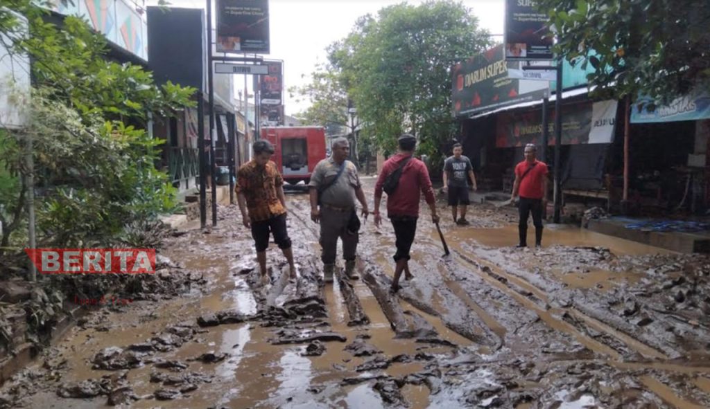 Tim Pemadam Kebakaran (Damkar) Kabupaten Pati membersihkan material lumpur sisa banjir di Kelurahan Kalidoro, Kabupaten Pati pada Jumat, 15 Juli 2022. (Arif Febriyanto/Beritajateng.id)