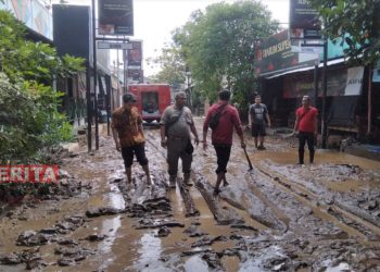 Tim Pemadam Kebakaran (Damkar) Kabupaten Pati membersihkan material lumpur sisa banjir di Kelurahan Kalidoro, Kabupaten Pati pada Jumat, 15 Juli 2022. (Arif Febriyanto/Beritajateng.id)