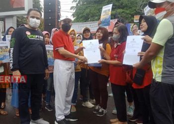 SIMBOLIS: Bupati Pati, Haryanto saat menyerahkan dokumen perizinan kepada masyarakat pada Minggu, 17 Juli 2022. (Ika Tamara Dewi/Koran Lingkar)