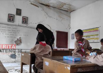 Guru SDN 2 Dresi Kulon, Kecamatan Kaliori, Kabupaten Rembang saat mengajar siswa di dalam ruang kelas yang rusak. (R. Teguh Wibowo/Koran Lingkar)