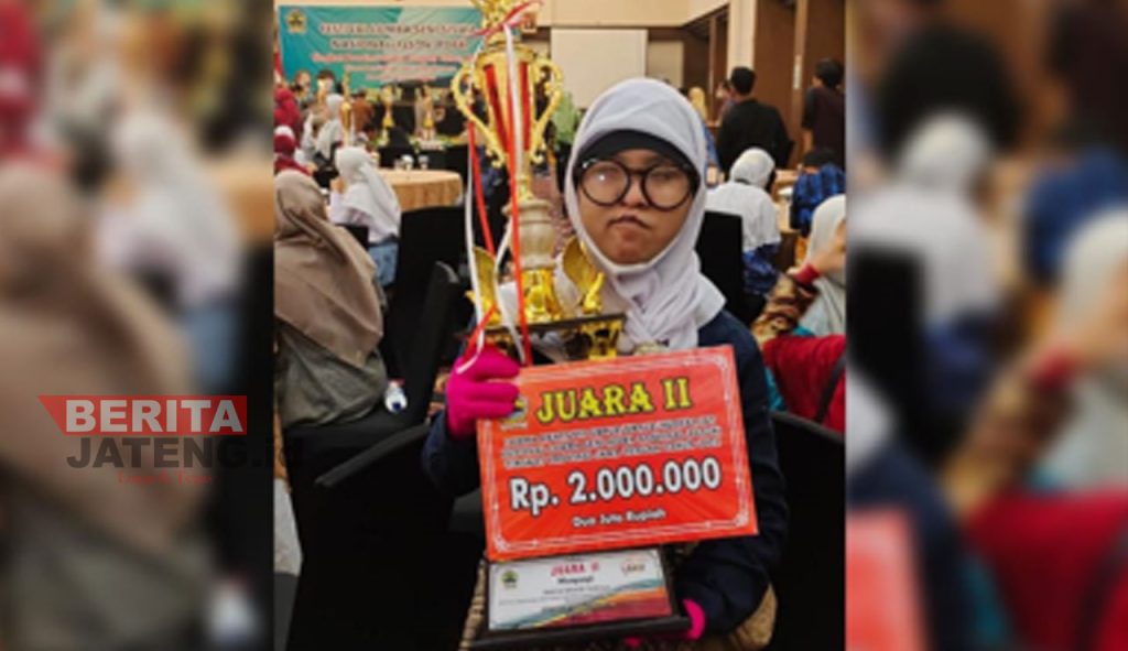 Veronica Intan Pramesti, salah satu siswa SLB Blora sedang membawa piala juara menyanyi dalam Festival Lomba Seni Siswa Nasional tahun 2022 tingkat Provinsi Jawa Tengah. (Lilik Yuliantoro/Koran Lingkar)
