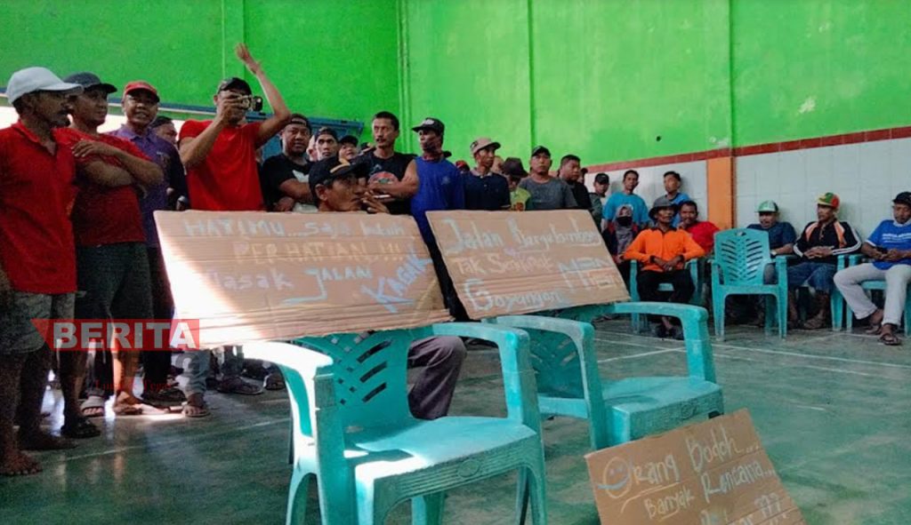 Warga Mangunsari, Kecamatan Tegowanu, Kabupaten Grobogan menggelar aksi di Balai Desa Mangunsari dengan membawa poster berisi tuntutan pada Senin, 18 Juli 2022. (Muhamad Ansori/Koran Lingkar)