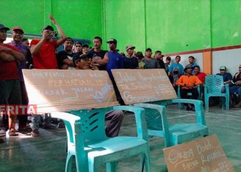 Warga Mangunsari, Kecamatan Tegowanu, Kabupaten Grobogan menggelar aksi di Balai Desa Mangunsari dengan membawa poster berisi tuntutan pada Senin, 18 Juli 2022. (Muhamad Ansori/Koran Lingkar)