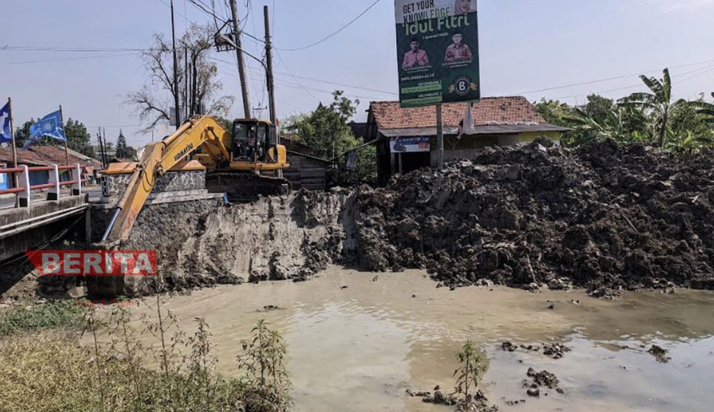Alat berat yang digunakan untuk mengeruk sedimentasi saluran irigasi Klambu Kiri. (Tomi Budianto/Koran Lingkar)