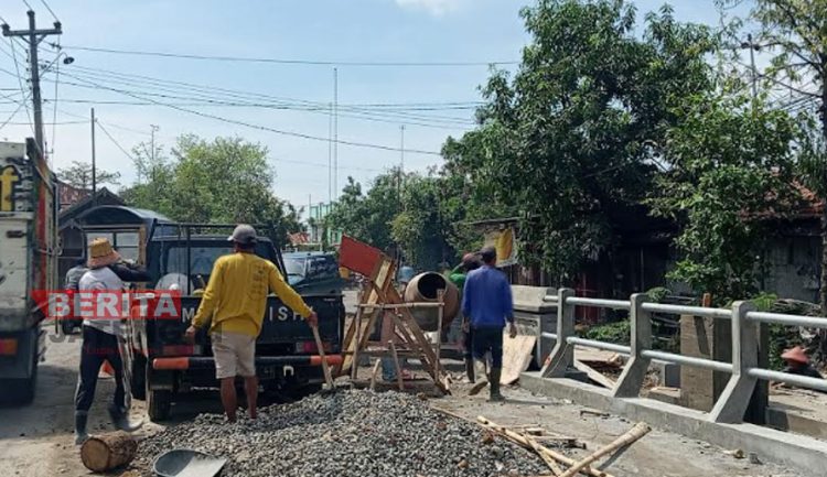 Terlihat beberapa tukang sedang melakukan pembangunan di Jembatan Kembar, Desa Langgenharjo, Kecamatan Juwana, Kabupaten Pati. (Aziz Afifi/Koran Lingkar)