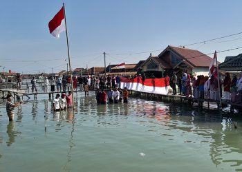 Warga Timbulsloko Demak Laksanakan Upacara HUT RI ke-79 di Tengah Banjir Rob